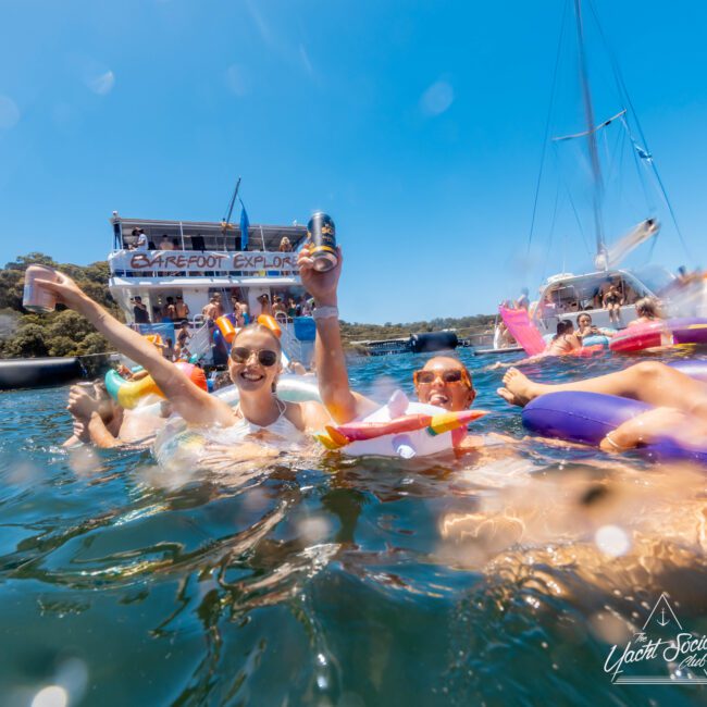 A group of people floating in the water, enjoying a day with Sydney Harbour Boat Hire The Yacht Social Club.